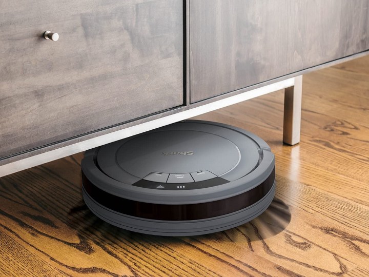 The Shark ION AV753 robot vacuum cleaning under furniture.